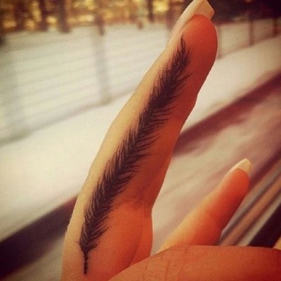 Tatouage plume sur le doigt avec le signe infini